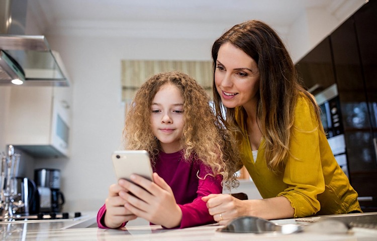 Tipps: Was Eltern beim ersten Smartphone für Kinder beachten sollten (Bild mit KI bearbeitet) Mutter erklärt ihrer Tochter die Smartphone-Nutzung