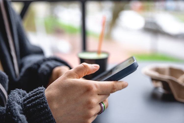 Frau nutzt Smartphone im Café